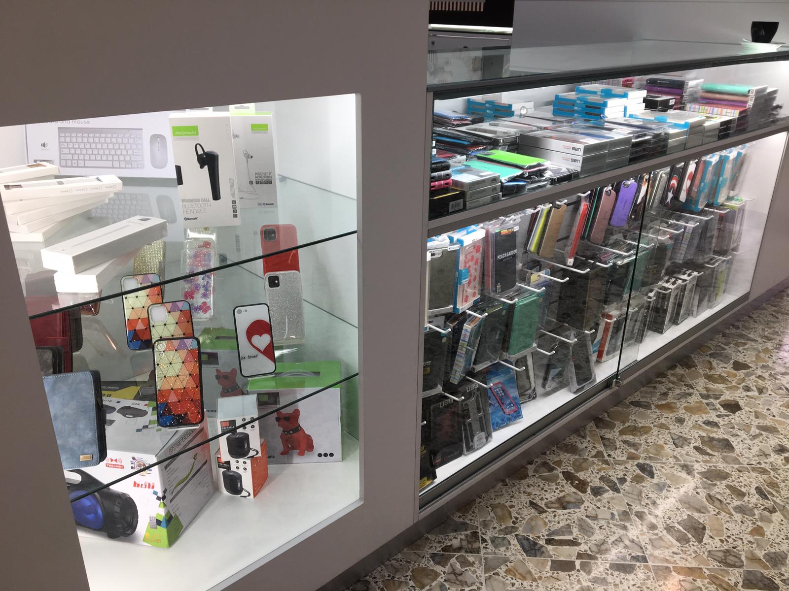 Glass cabinets at the kiosk with keyboards, headsets, cases and speakers